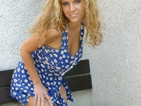 Sexy blonde strips to her high heels on a bench outside a building